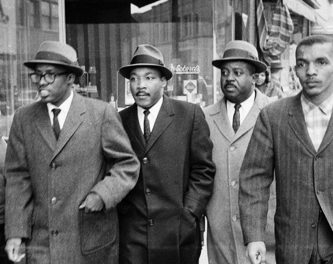 Rev, Douglas Moore, pastor of the Asbury Temple Methodist Church, Dr. Martin Luther King, Jr., Ralph Abernathy and NCCU student Lacy Streeter walk along West Main Street on their way to the Woolworth Lunch Counter in this fie photo of February 16,1960.