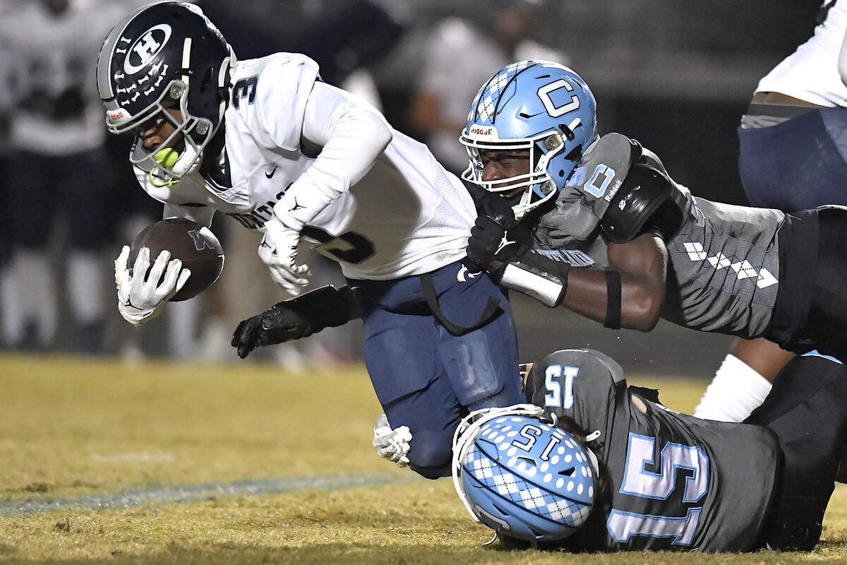 Heritage running back LaDainian Person (3) dives for yardage against Cleveland linebackers Jaylen King (9) and Aiden Stephenson (15) during the first half. The Cleveland Rams and the Heritage Huskies met in the first round of the NCHSAA 4A playoffs in Clayton, N.C. on November 15, 2024.