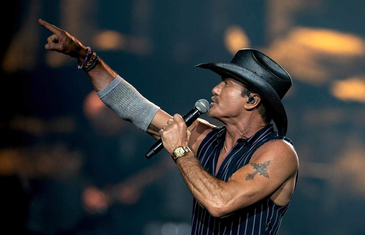 Tim McGraw points to fans in the upper level of Raleigh’s PNC Arena, Saturday, June 22, 2024.
