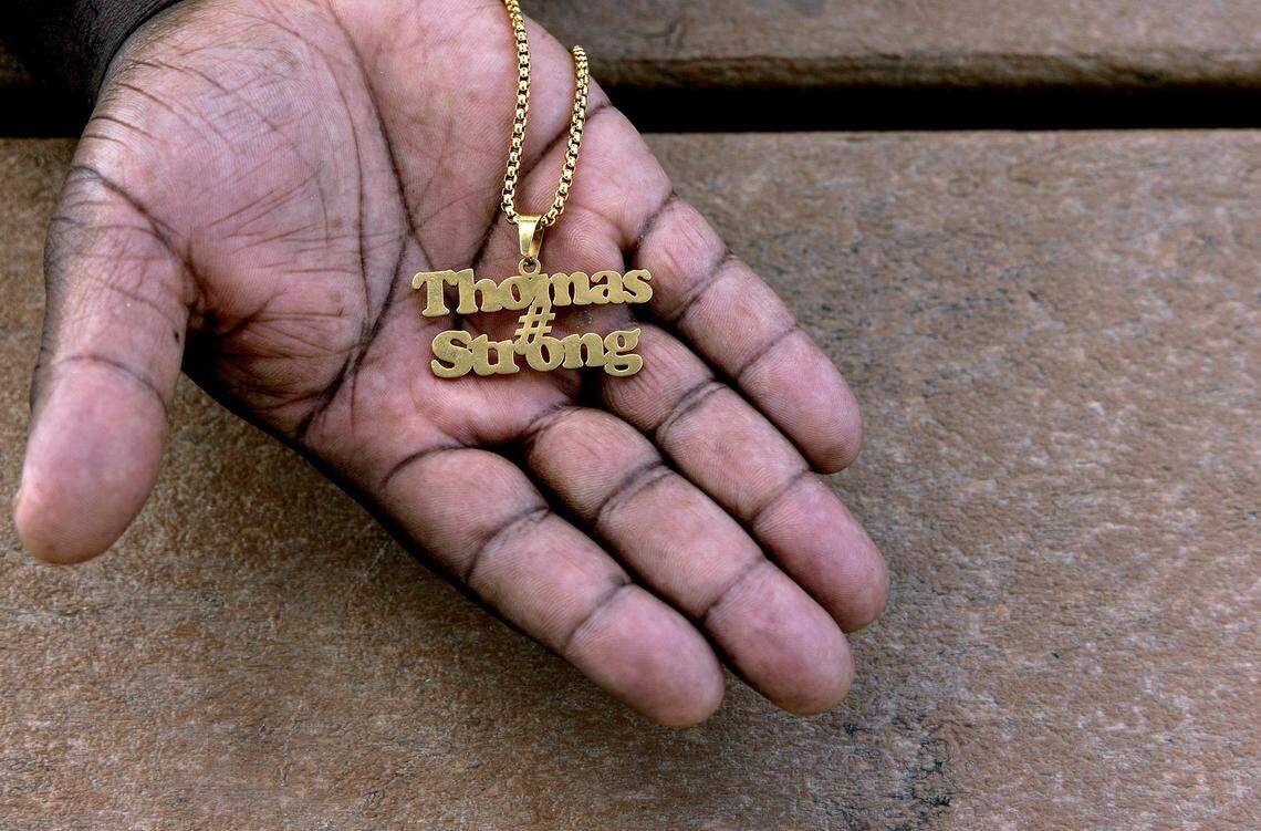 Atari Thomas holds a necklace his late wife, Tiffany, had made to celebrate their family.