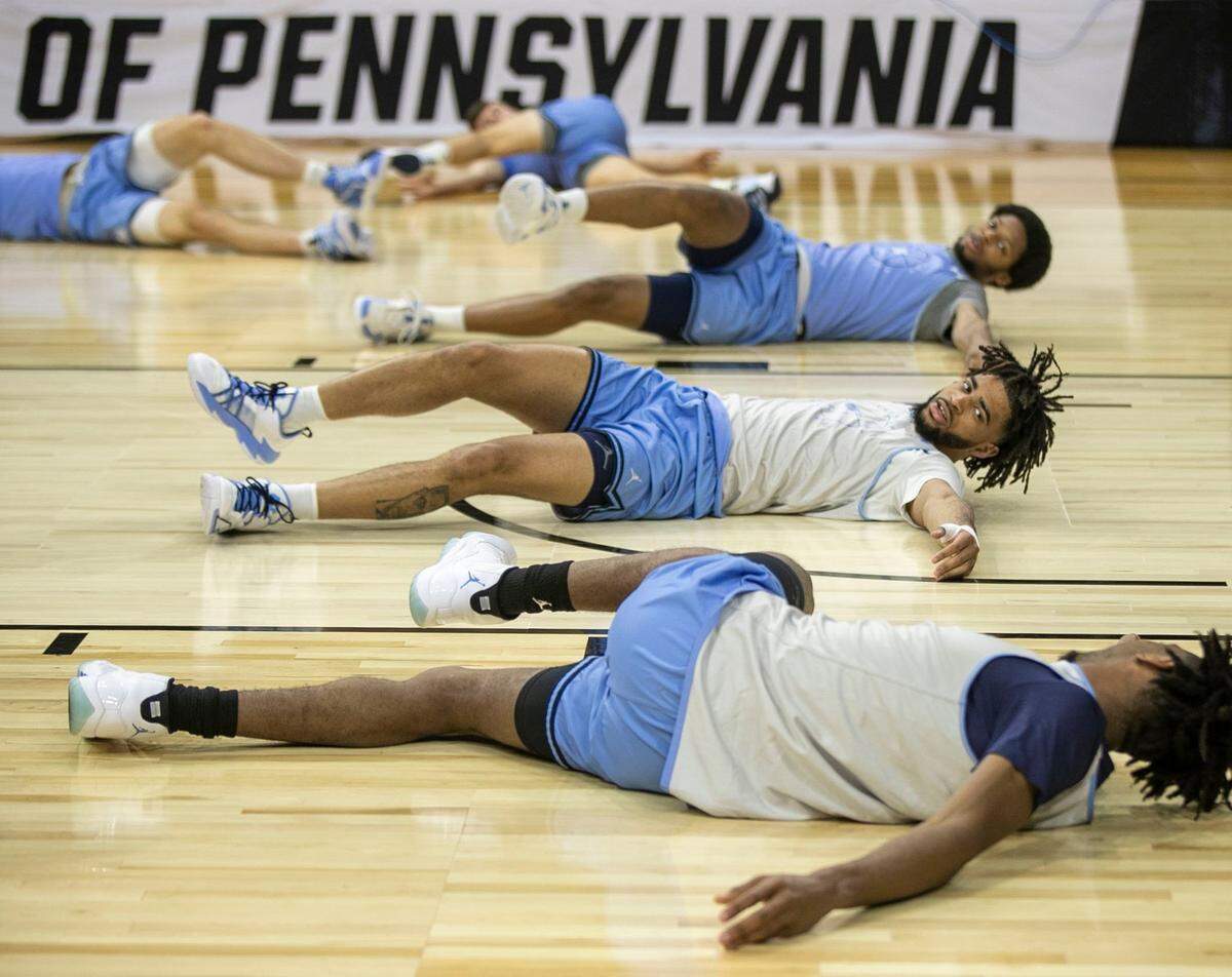 North Carolinas R.J. Davis (4) talks with teammate Leaky Black (1) as they stretch during the Tar Heels open practice on Thursday, March 24, 2022 at Wells Fargo Center in Philadelphia, Pa.