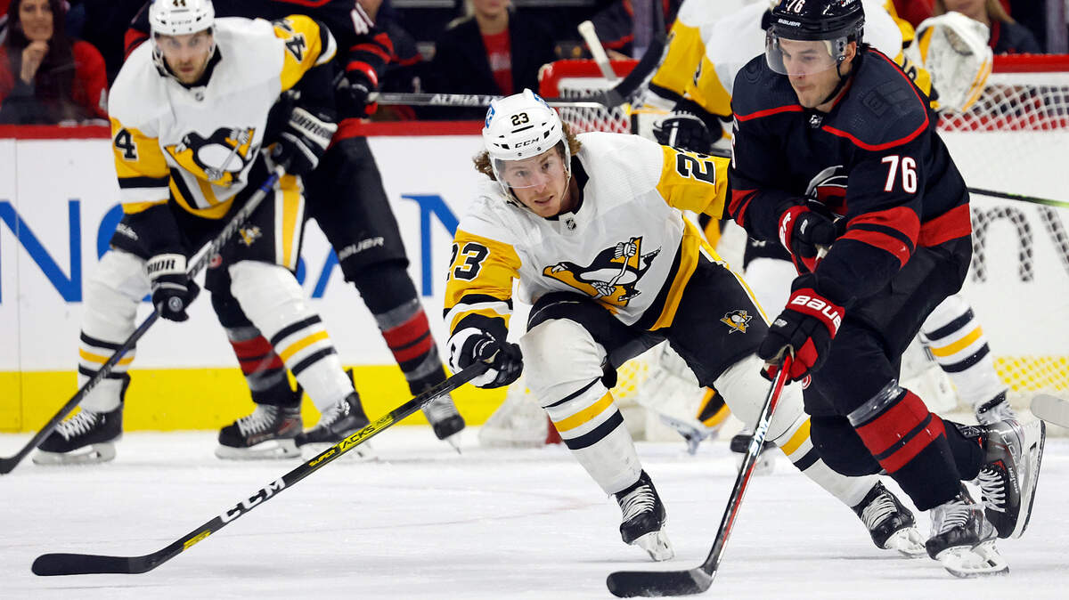 Carolina Hurricanes’ Brady Skjei (76) moves the puck around Pittsburgh Penguins’ Brock McGinn (23) during the first period of an NHL hockey game in Raleigh, N.C., Saturday, Jan. 14, 2023. (AP Photo/Karl B DeBlaker)