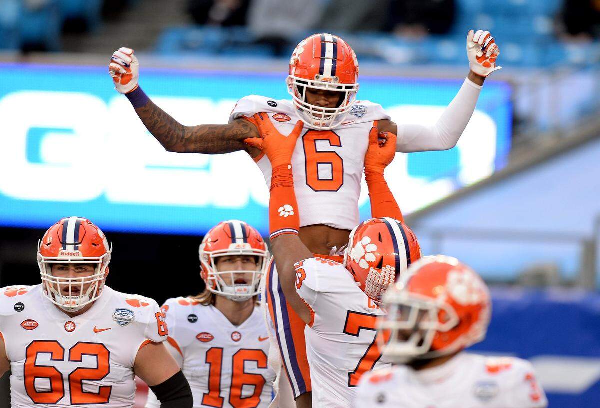 Clemson Tigers wide receiver E.J. Williams is lifted into the air by a teammate after catching a 33-yard touchdown pass from quarterback Trevor Lawrence during Clemson’s 34-10 win over Notre Dame Saturday in the ACC Championship in Charlotte.