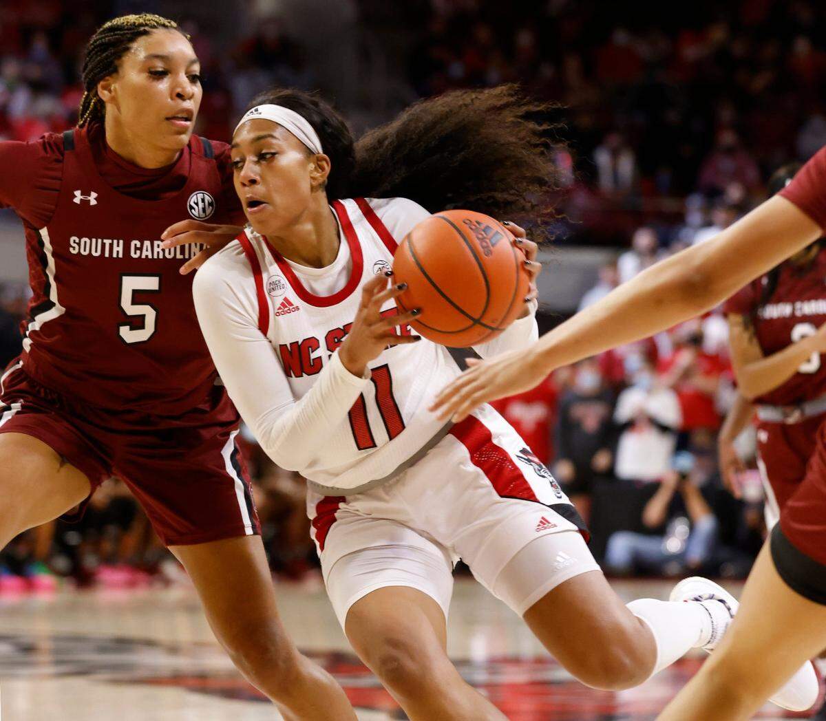 N.C. State’s Jakia Brown-Turner (11) drives around South Carolina’s Victaria Saxton (5) during the second half of South Carolinas 66-57 victory over N.C. State at Reynolds Coliseum in Raleigh, N.C., Tuesday, November 9, 2021.