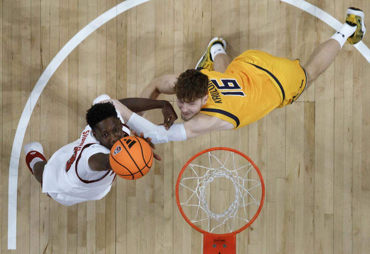 N.C. State’s Musa Sagnia pulls down a rebound over UNC Greensboro’s Domas Kauzonas during the first half of the Wolfpack’s 110-64 win on Wednesday, Nov. 12, 2025, at Lenovo Center in Raleigh, N.C.