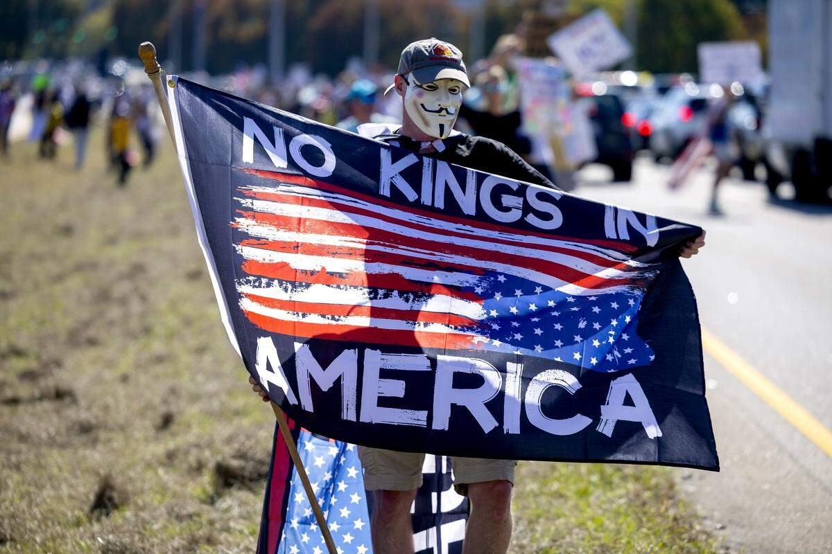 ’No Kings’ demonstrators stand in the median between traffic lanes along Capital Blvd, during a more than three-hour protest, on Saturday, October 18, 2025 in Raleigh, N.C. 