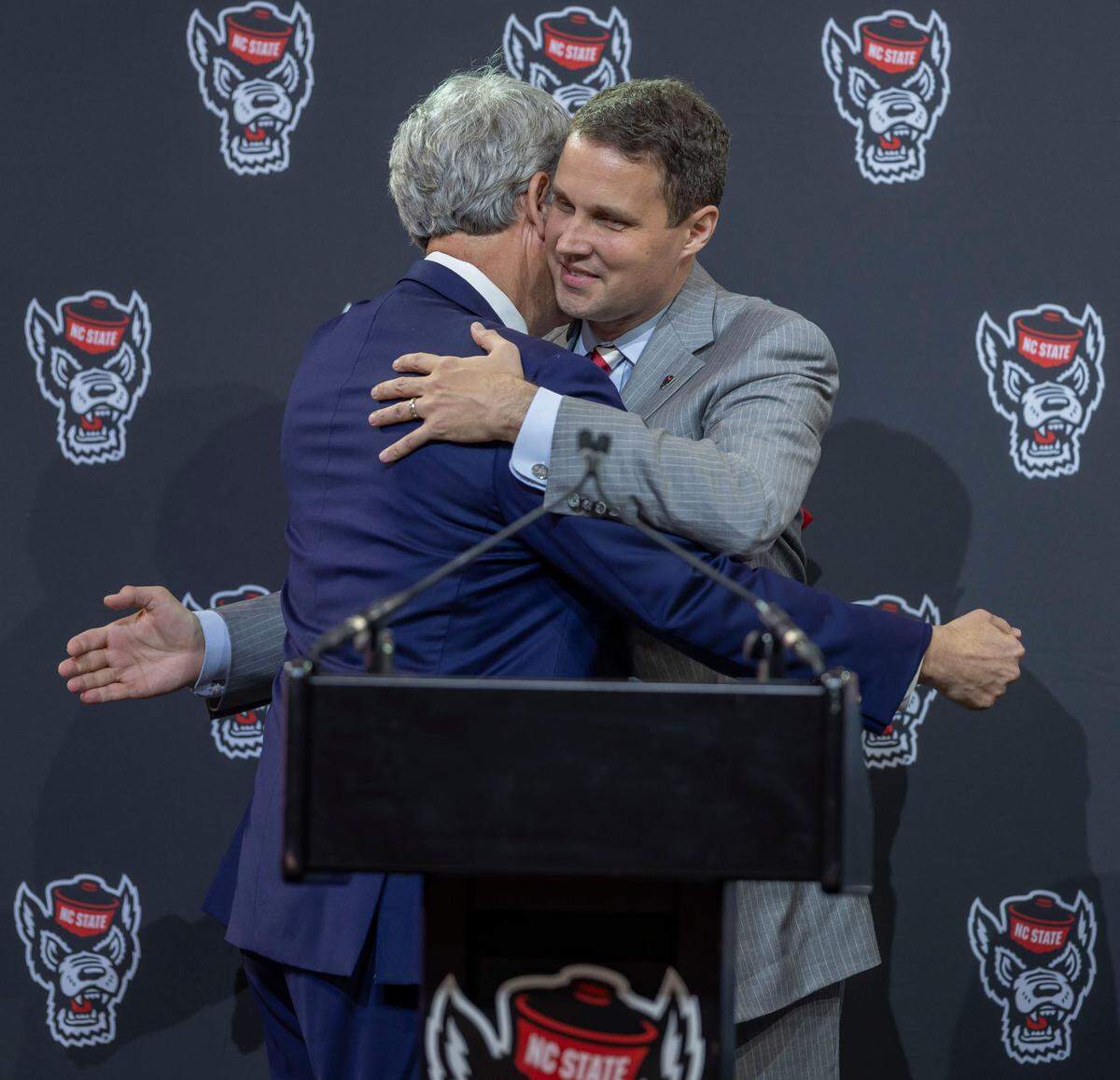 N.C. State athletic director Boo Corrigan embraces Will Wade after introducing him as the new men’s basketball on Tuesday, March 25, 2025 at Reynolds Coliseum in Raleigh, N.C.