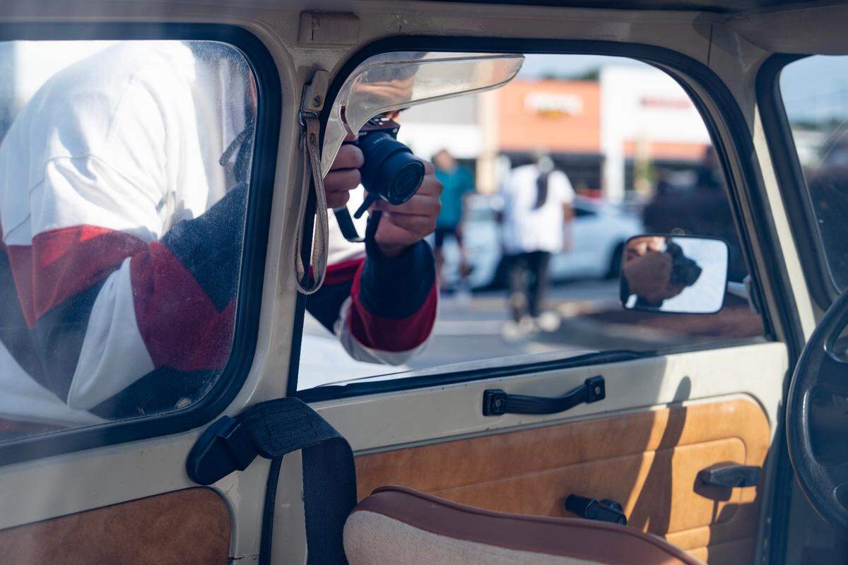 A passerby takes pictures of the Armbrusters’ Trabant at Cars and Coffee Morrisville on June 7, 2025.