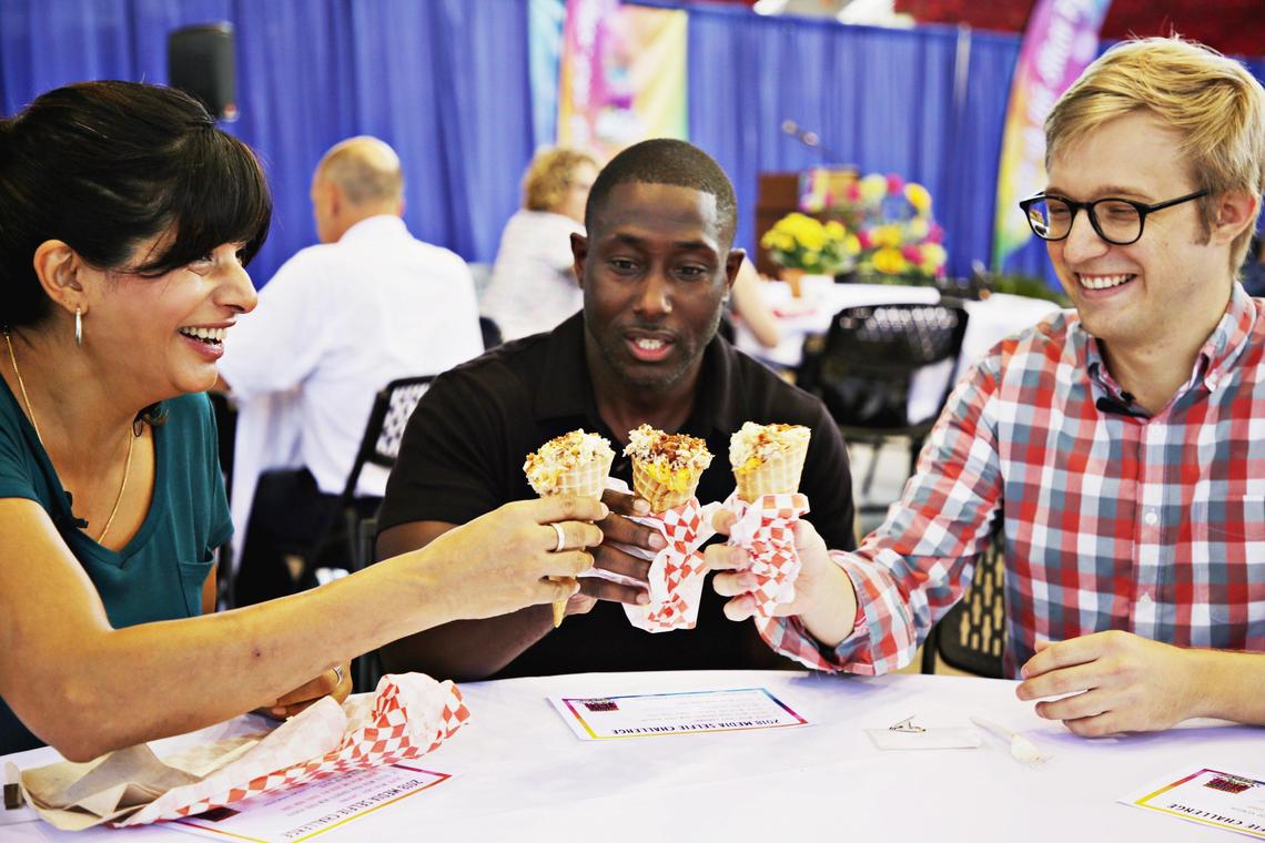 From left, chef Cheetie Kumar, Mike Williams and Drew Jackson, both from The News & Observer, start their taste-test of the 2018 State Fair Food with mac and cheese with barbecue inside a waffle cone on Monday, Oct. 8, 2018.