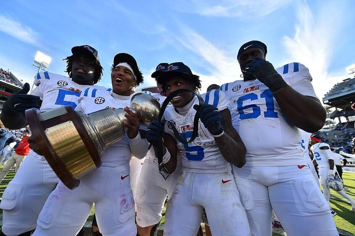 STARKVILLE, MISSISSIPPI - NOVEMBER 28: Mississippi Rebels players pose with the Golden Egg trophy after the game against the Mississippi State Bulldogs at Davis Wade Stadium on November 28, 2025 in Starkville, Mississippi. (Photo by Justin Ford/Getty Images)