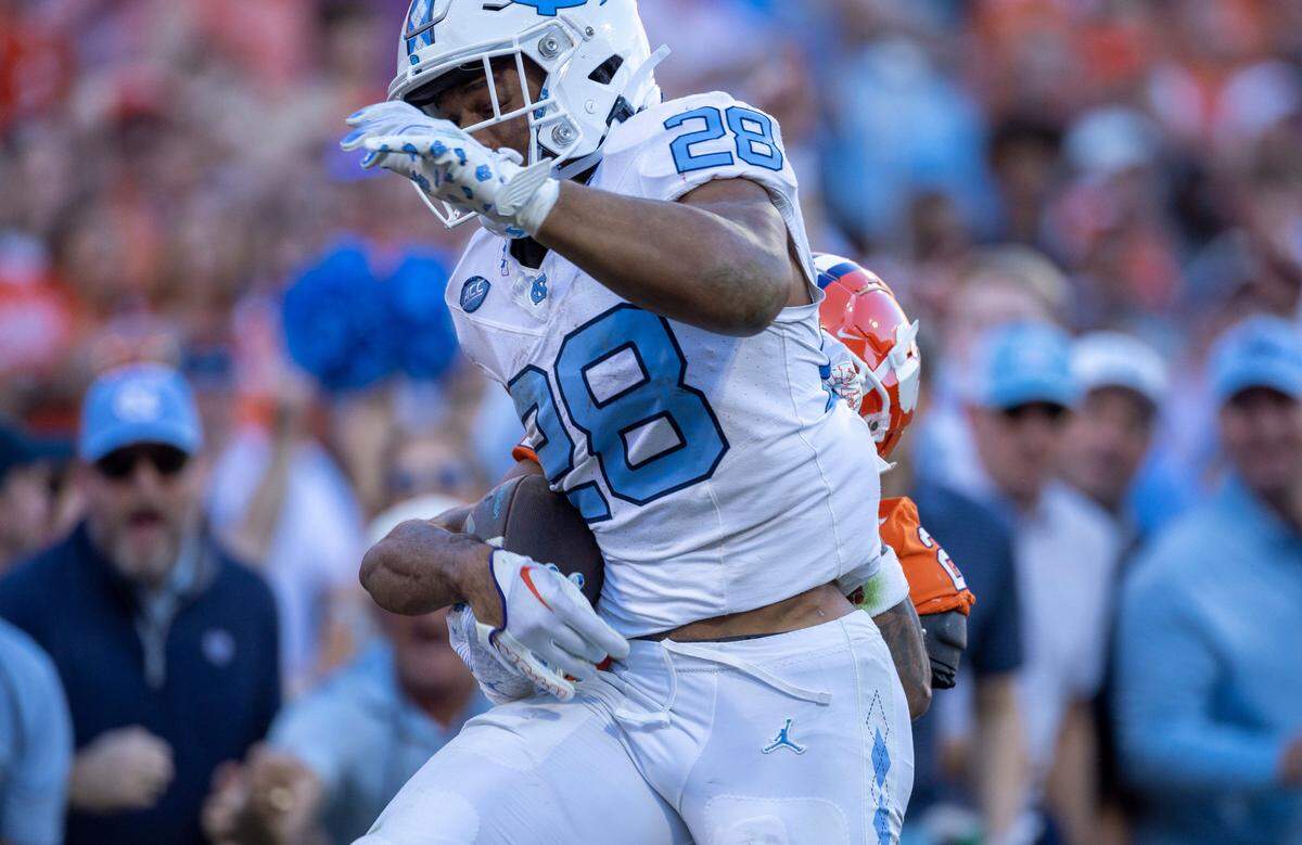 Clemson’s Nate Wiggins (2) strips the ball from North Carolina’s Omarion Hampton (28) as he crosses the goal line on a 64-yard run, prevented the score in the first quarter on Saturday, November 18, 2023 at Memorial Stadium in Clemson, S.C.