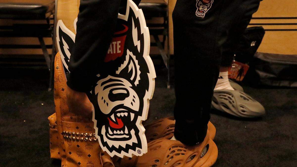 N.C. State’s KJ Keatts holds a Wolfpack sign in the locker room following a 79-73 overtime win against Oakland in the second round of the NCAA Tournament on Saturday, March 23, 2024, at PPG Paints Arena in Pittsburgh, Pa.