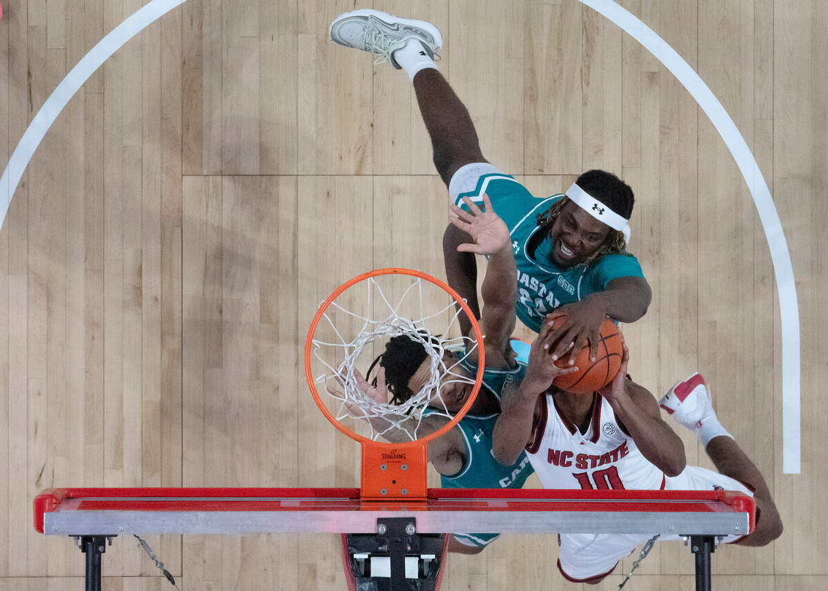 N.C. State’s Marcus Hill drives to the basket against Coastal Carolina’s Joshua Meo and Denzel Hines during the first half of the Wolfpack’s 82-70 win on Wednesday, Nov. 13, 2024, at Lenovo Center in Raleigh, N.C.