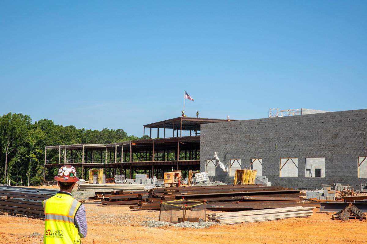 Construction workers lay the final structural beam for Felton Grove High School in Holly Springs in June 2024. The school is scheduled to open in August 2025.