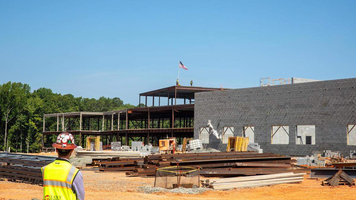 Construction workers lay the final structural beam for Felton Grove High School in Apex, N.C., in June 2024. The school is scheduled to open in August 2025.