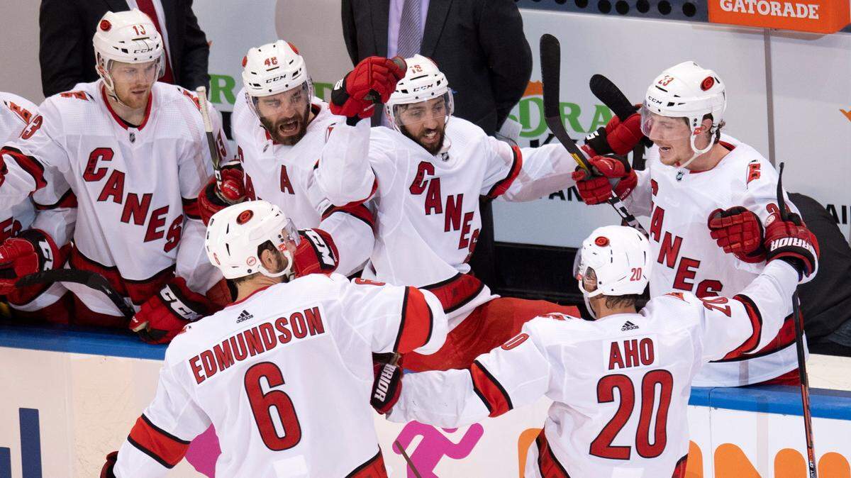 Carolina Hurricanes center Sebastian Aho (20) is congratulated by teammates Joel Edmundson (6) , Warren Foegele (13), Jordan Martinook (48), Vincent Trocheck (16) and Brock McGinn (23) after scoring against the New York Rangers during the third period of an NHL hockey playoff game Tuesday, Aug. 4, 2020, in Toronto. (Frank Gunn/The Canadian Press via AP)