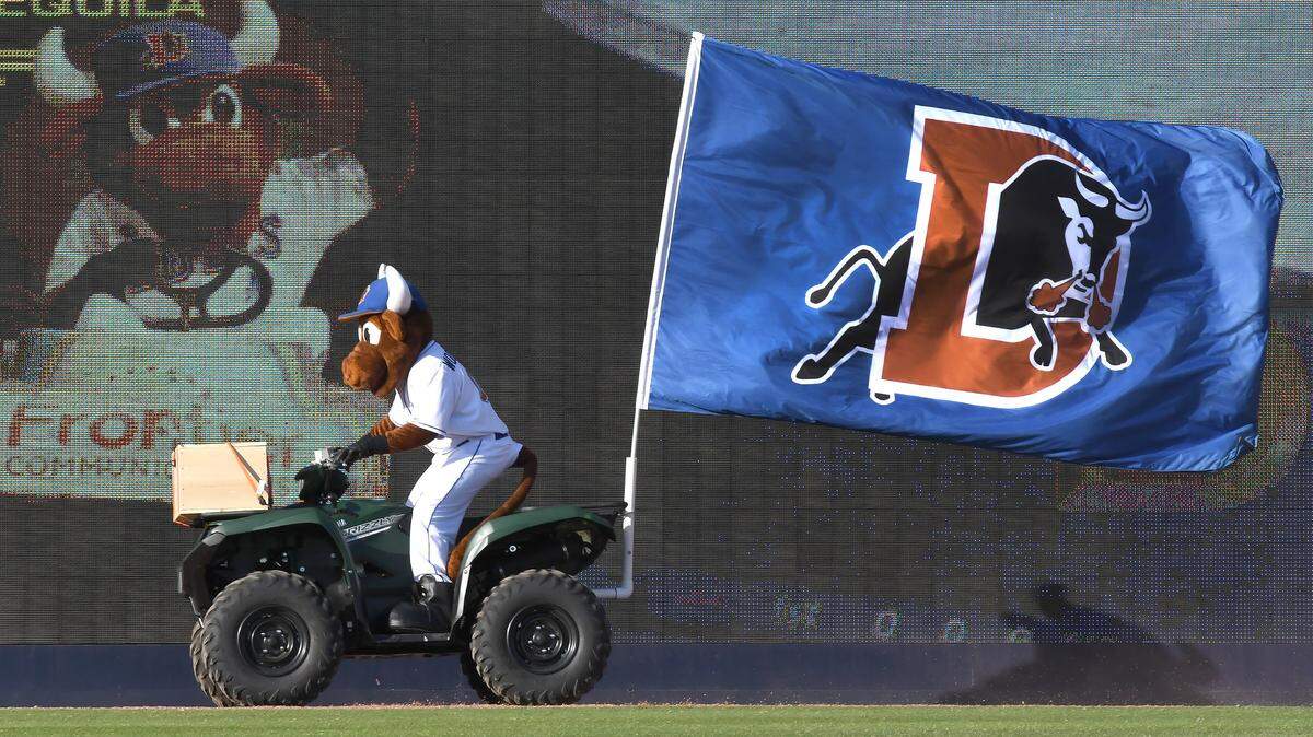 Wool E. Bull races around the warning track with the Durham Bulls flag as opening day ceremonies start for the Triple A National Champions Thursday, April 5, 2018 in Durham, N.C.