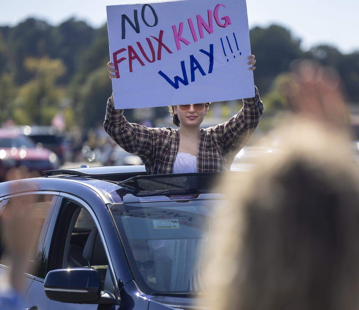 Demonstrators in cars cruise along Capital Blvd. interacting with those lining the road during the ‘No Kings’ protest on Saturday, October 18, 2025 in Raleigh, N.C