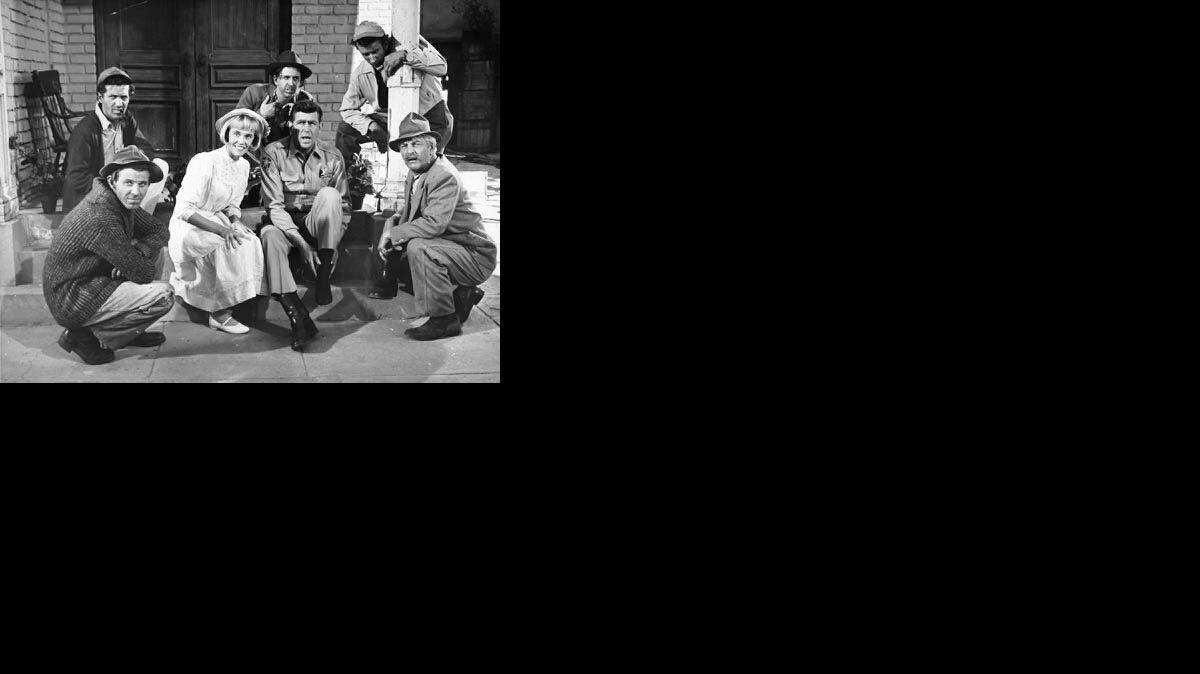 The Darlings on “The Andy Griffith Show” were really The Dillards, an already established bluegrass group from Missouri, plus actors Denver Pyle (Briscoe) and Maggie Peterson (Charlene), seated next to Andy Griffith (Andy Taylor).