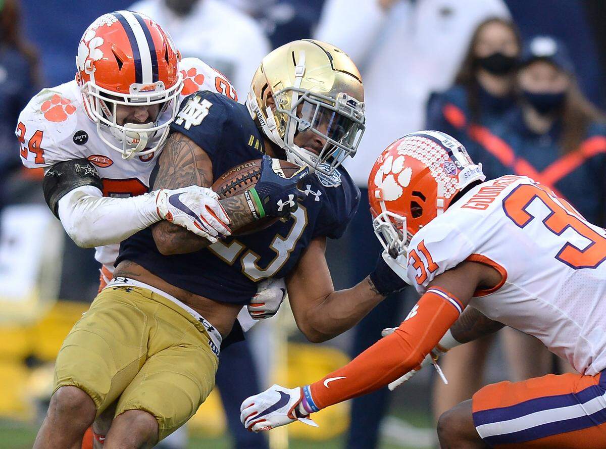 Clemson Tigers safety Nolan Turner, left and cornerback Mario Goodrich, right, make the tackle on Notre Dame running back Kyren Williams, center, during first quarter action at Bank of America Stadium on Saturday, December 19, 2020 in Charlotte, NC. The Clemson Tigers and Notre Dame Fighting Irish faced off in the ACC Championship game.