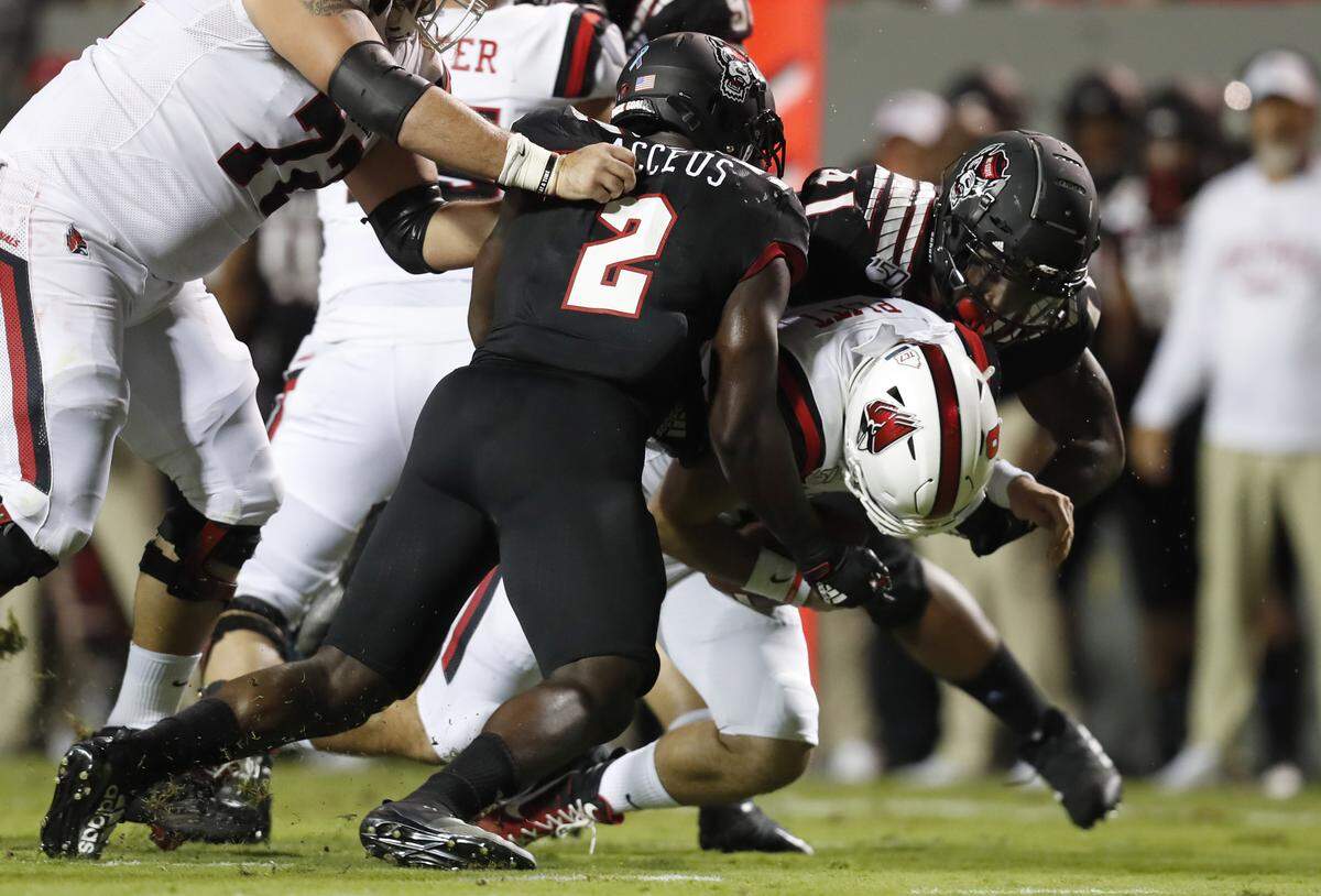 N.C. State’s Louis Acceus (2) and Isaiah Moore (41) sack Ball State quarterback Drew Plitt (9) during the first half of N.C. State’s game against Ball State at Carter-Finley Stadium in Raleigh, N.C. Saturday, Sept. 21, 2019.