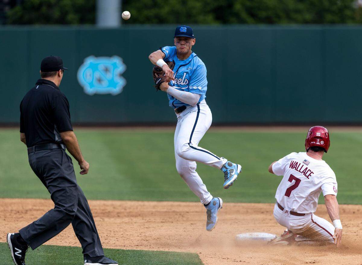North Carolina short stop Danny Serretti (1) throws to first to turn a double play after forcing out Arkansas Cayden Wallace (7) at second base in the fifth inning during game two of their NCAA Super Regional series on Sunday, June 12, 2022 at Boshamer Stadium in Chapel Hill, N.C.