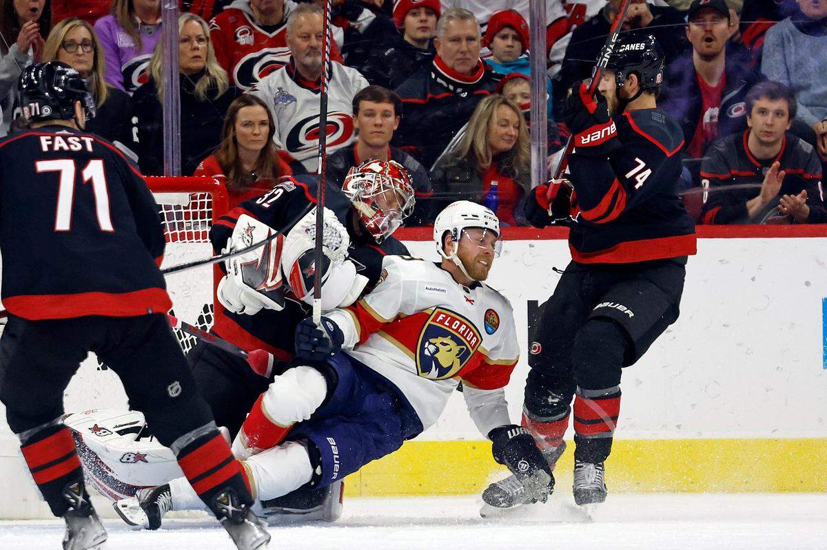 Florida Panthers’ Sam Bennett (9) collides with Carolina Hurricanes goaltender Antti Raanta (32) with Hurricanes’ Jaccob Slavin (74) nearby during the second period of an NHL hockey game in Raleigh, N.C., Friday, Dec. 30, 2022. (AP Photo/Karl B DeBlaker)