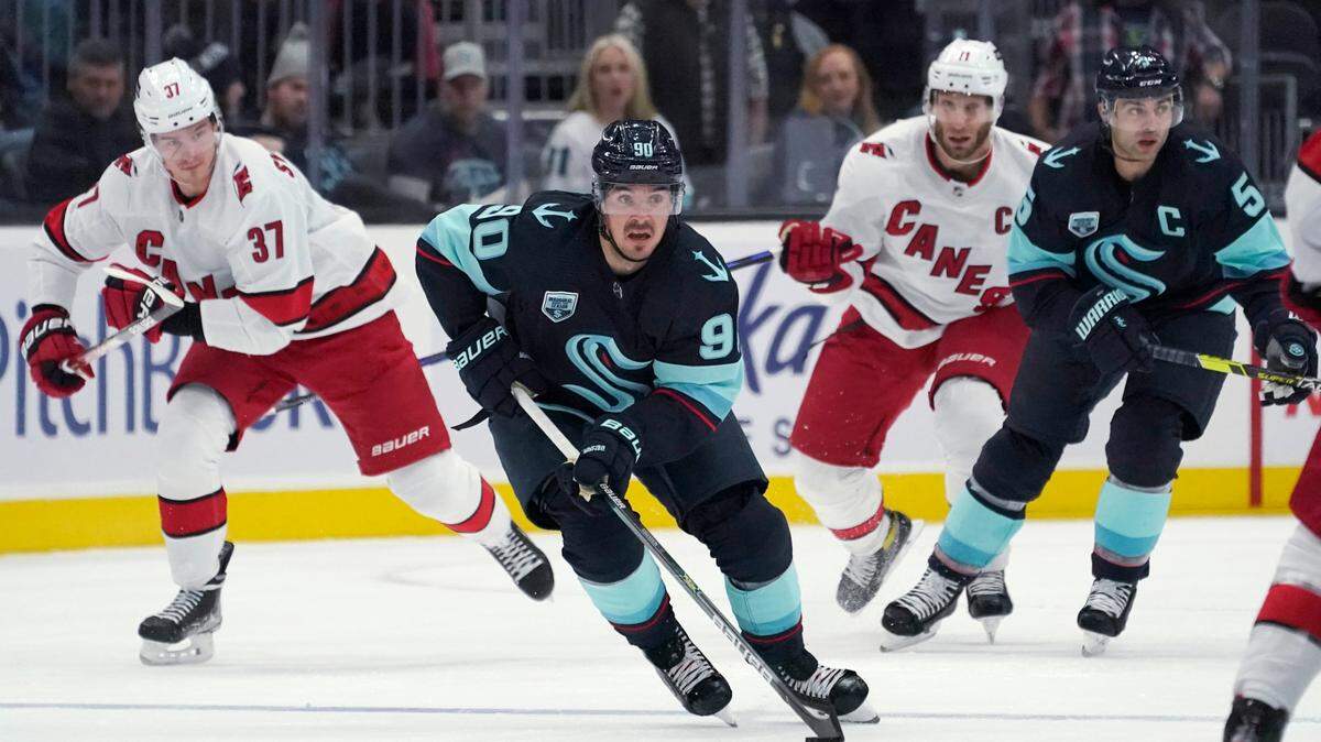 Seattle Kraken center Marcus Johansson (90) moves the puck near Carolina Hurricanes right wing Andrei Svechnikov (37) during the first period of an NHL hockey game Wednesday, Nov. 24, 2021, in Seattle. (AP Photo/Ted S. Warren)