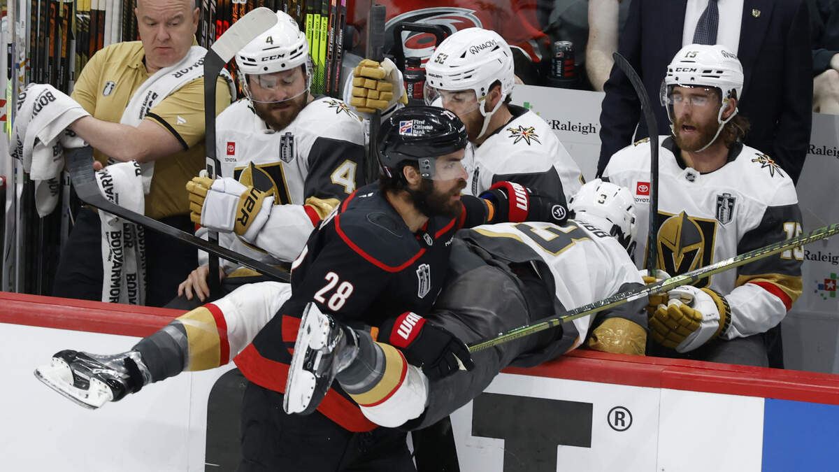 The Canes’ William Carrier (28) checks the Golden Knights’ Brayden McNabb (3) into the Vegas bench early in the first period of Game 5.