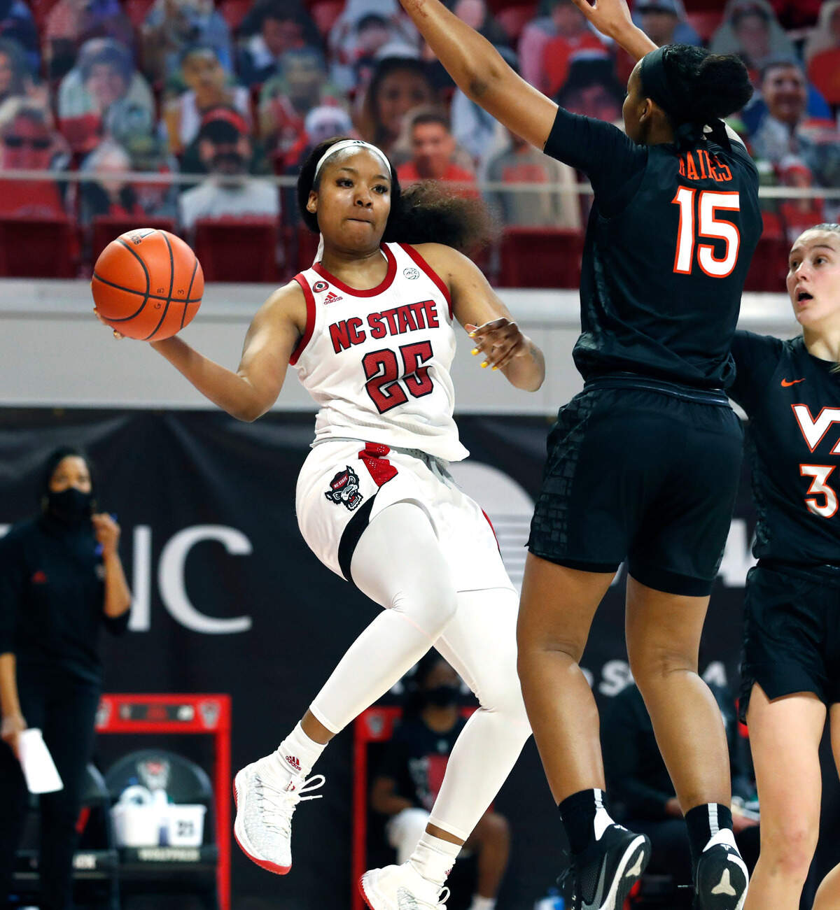N.C. State’s Kayla Jones (25) passes around Virginia Tech’s Azana Baines (15) during the second half of N.C. State’s 89-87 victory over Virginia Tech at Reynolds Coliseum in Raleigh, N.C., Sunday, January 24, 2021.