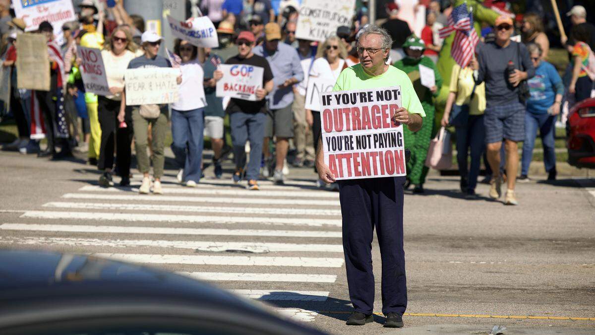 No Kings protester Mark Miller of Sanford crosses Sumner Blvd. at Capital Blvd. in Raleigh, Saturday, Oct. 18, 2025.