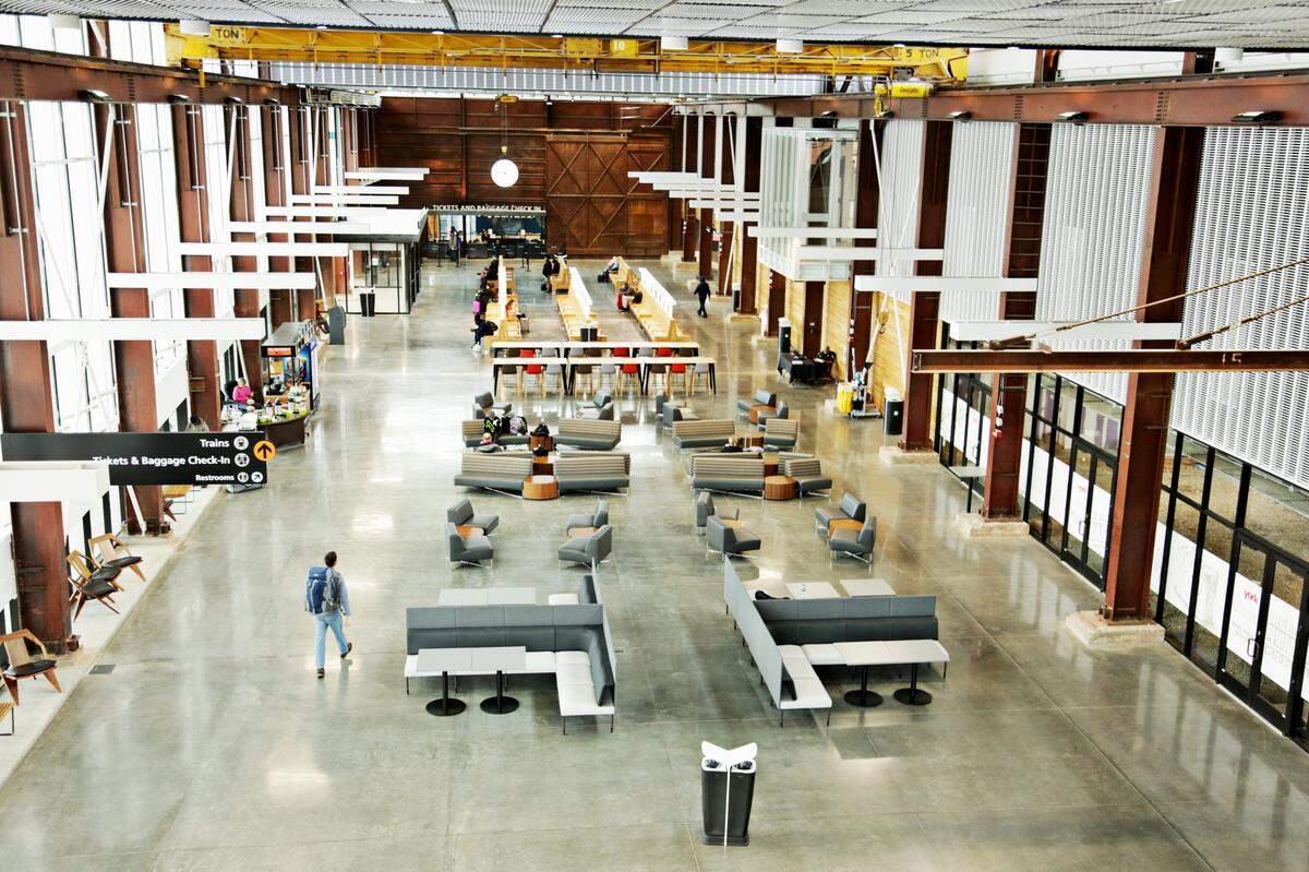The view of Union Station from the top of its stairs conveys a space that is wide open for hundreds of feet, and the eye is drawn across it toward a huge white clock atop ticket windows.