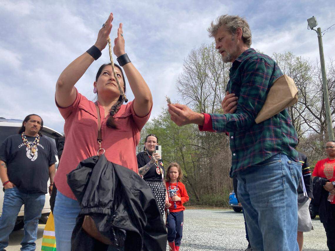 Outside the Mebane Antique Auction Gallery, TyAnn Nakai and Randy Newcomb burn sweetgrass and sage in a smudging ritual on Saturday, March 15, 2023. Nakai and Newcomb were at the auction to protest the sale of a purported 600-year-old human skull.