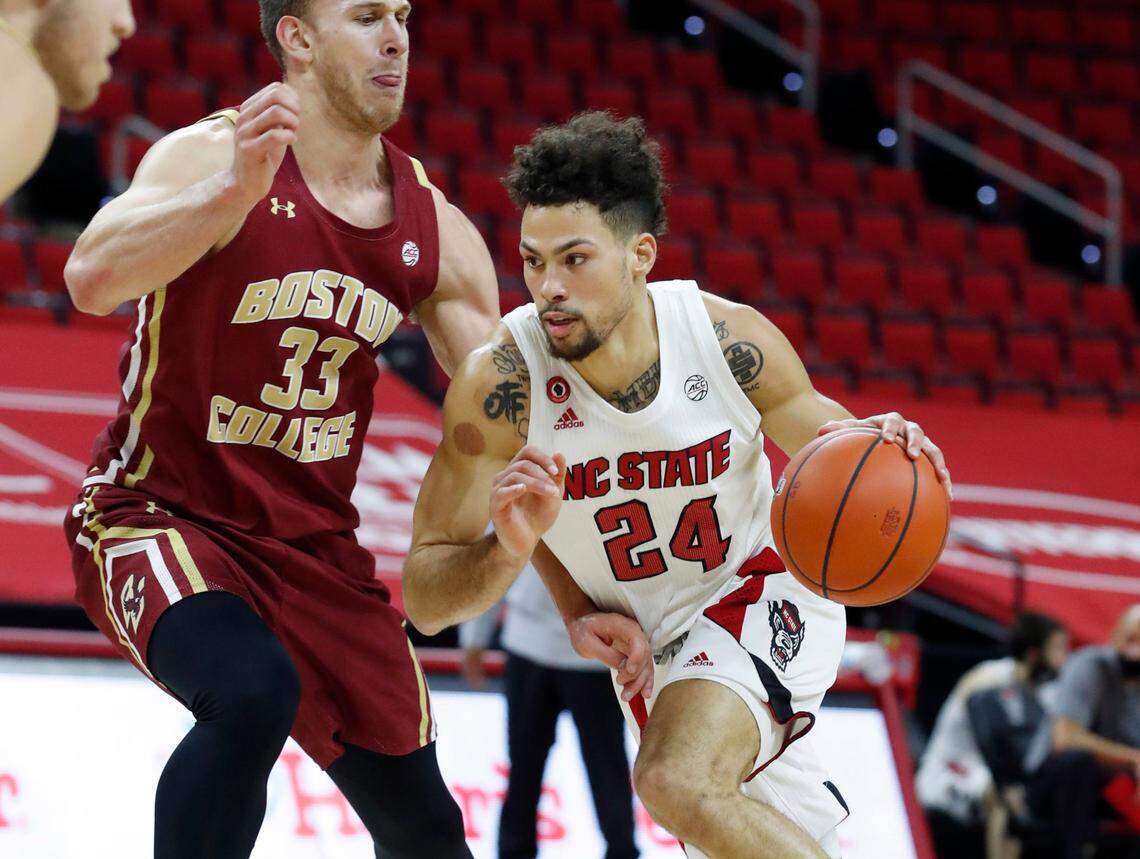 N.C. State’s Devon Daniels (24) drives by Boston College’s James Karnik (33) during the first half of N.C. State’s game against Boston College at PNC Arena in Raleigh, N.C., Wednesday, December 30, 2020.
