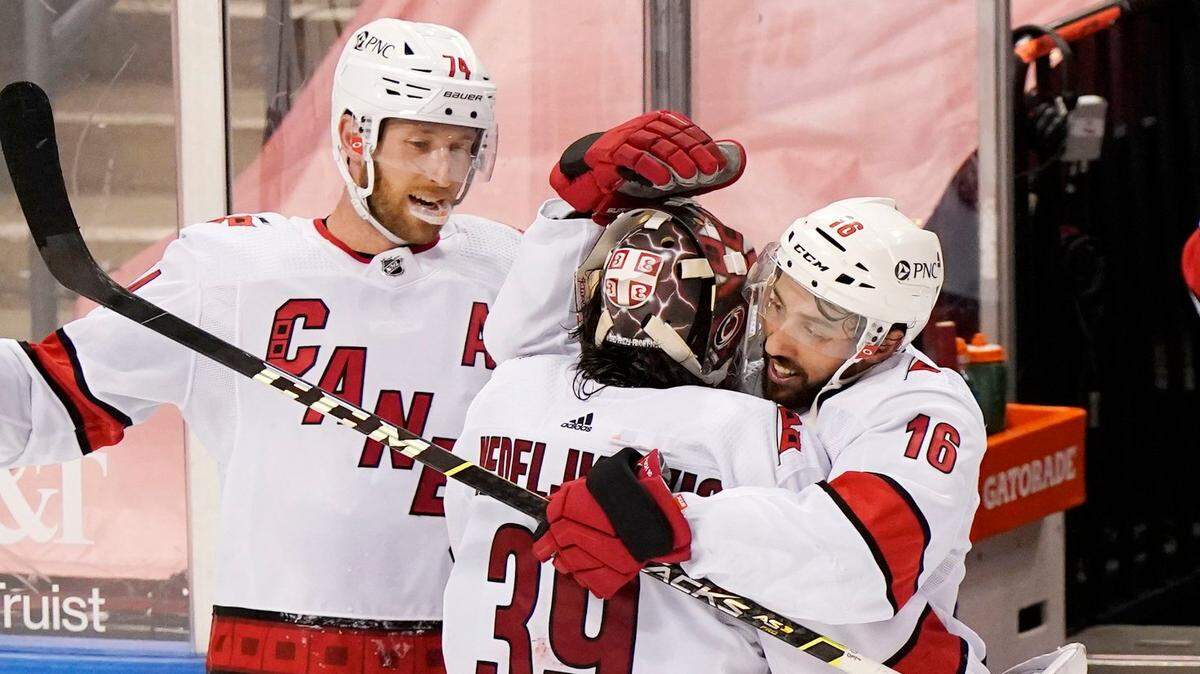 Carolina Hurricanes center Vincent Trocheck (16) and defenseman Jaccob Slavin (74) celebrate with goaltender Alex Nedeljkovic (39) after the Hurricanes defeated the Florida Panthers 3-2 in an overtime period of an NHL hockey game, Monday, March 1, 2021, in Sunrise, Fla. (AP Photo/Wilfredo Lee)