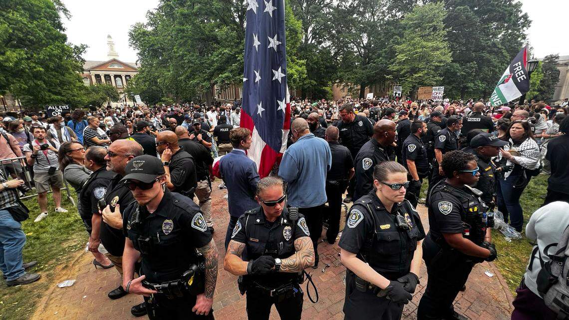UNC interim chancellor Lee Roberts (center left), prepares to raise the United States flag after protesters replaced in with a Palestinian flag during protests on campus, Tuesday, April 20, 2024.