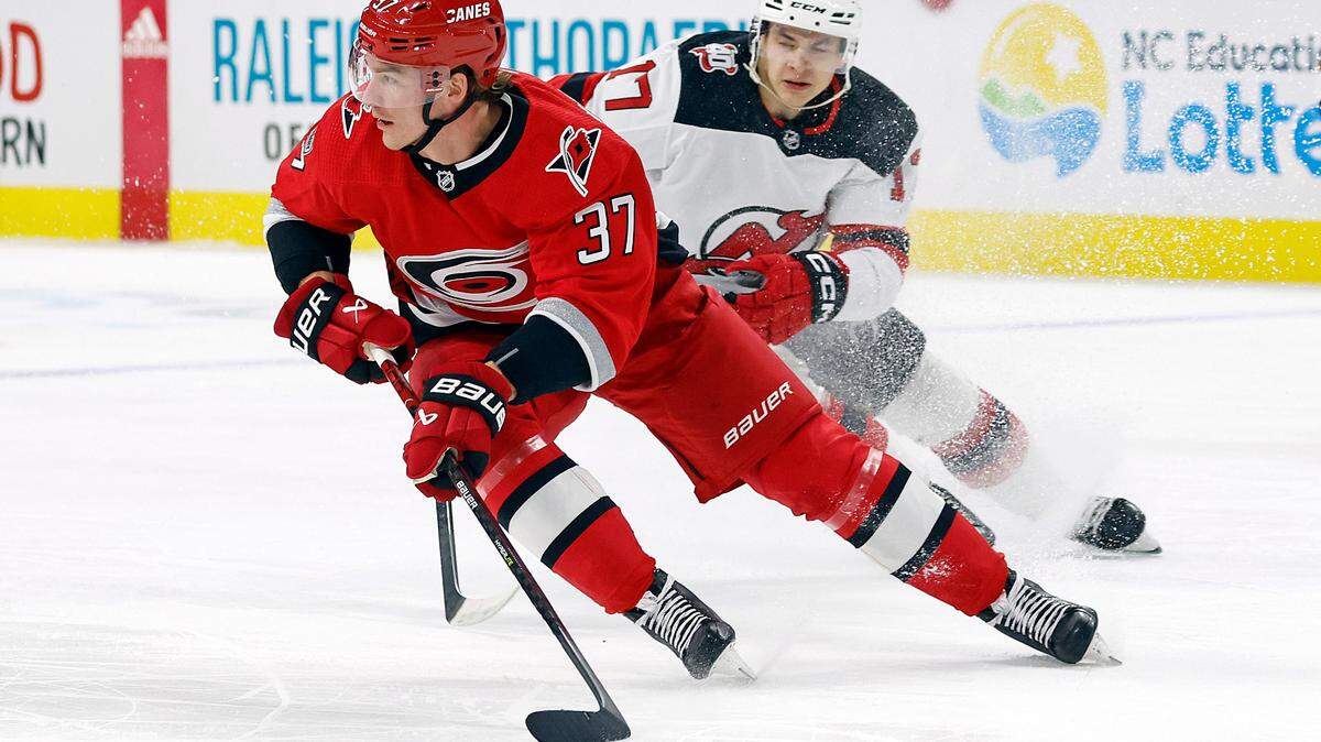 Carolina Hurricanes’ Andrei Svechnikov (37) skates with the puck away from New Jersey Devils’ Yegor Sharangovich during the first period of an NHL hockey game in Raleigh, N.C., Tuesday, Dec. 20, 2022. (AP Photo/Karl B DeBlaker)