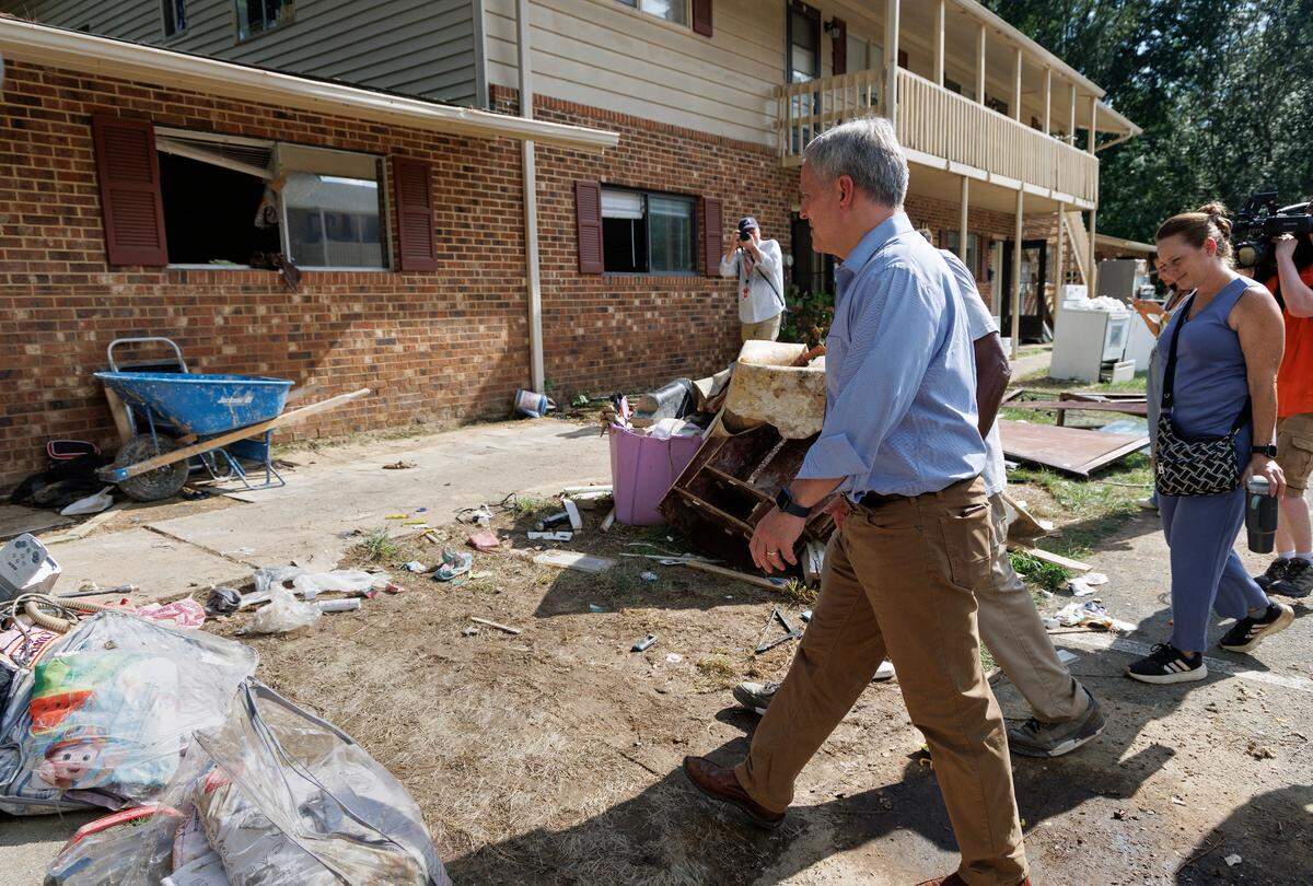N.C. Gov. Josh Stein walks with Camelot Village resident Shelton Stokes on Friday, July 18, 2025, during a tour of flood damage caused by remnants of Tropical Storm Chantal in Chapel Hill, N.C.
