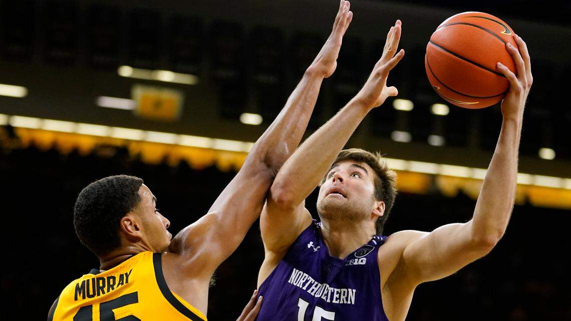 Northwestern center Ryan Young shoots over Iowa forward Keegan Murray, left, during the first half of an NCAA college basketball game, Monday, Feb. 28, 2022, in Iowa City, Iowa.