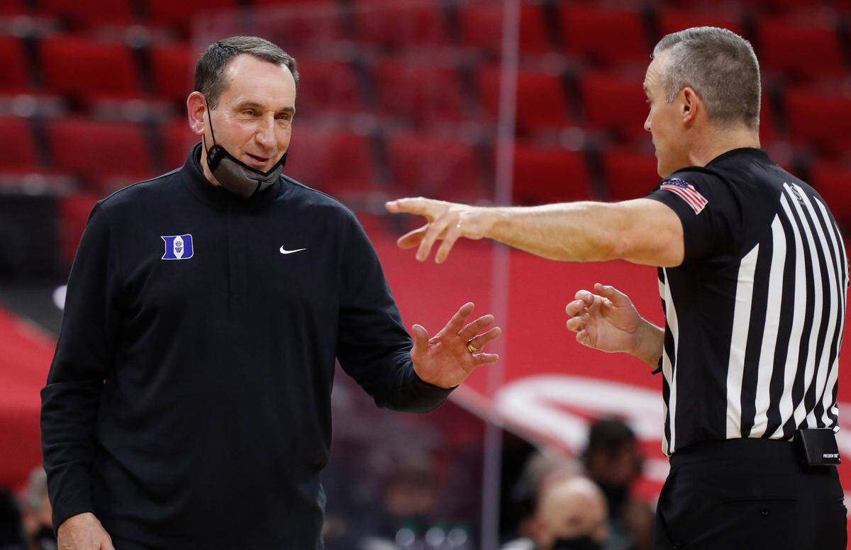 Duke head coach Mike Krzyzewski smiles while talking with official Ron Groover during the second half of Duke’s 69-53 victory over N.C. State at PNC Arena in Raleigh, N.C., Saturday, February 13, 2021.