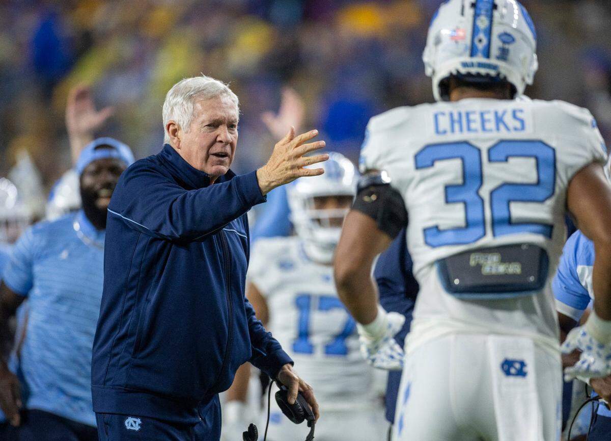 North Carolina coach Mack Brown congratulates his players after a 52-yards punt return by Alijah Huzzie (28) to give the Tar Heels a 21-14 lead over Pitt in the second quarter on Saturday, September 23, 2023 at Acrisure Stadium in Pittsburgh, Pa.