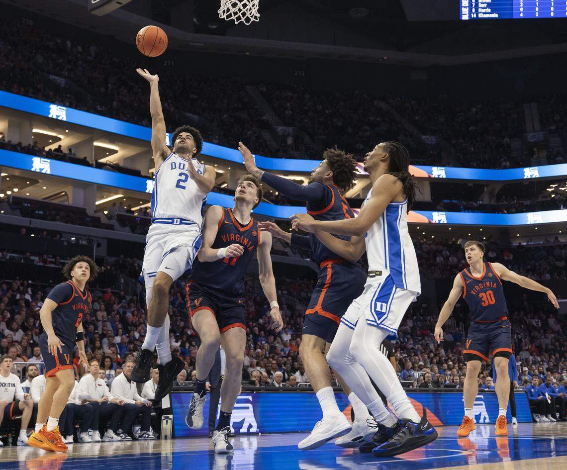 Duke guard Cayden Boozer (2) drives to the basket against Virginia forward Devin Tillis (11) in the first half on Saturday, March 14, 2026, during the ACC Tournament Championship at Spectrum Center in Charlotte, N.C.