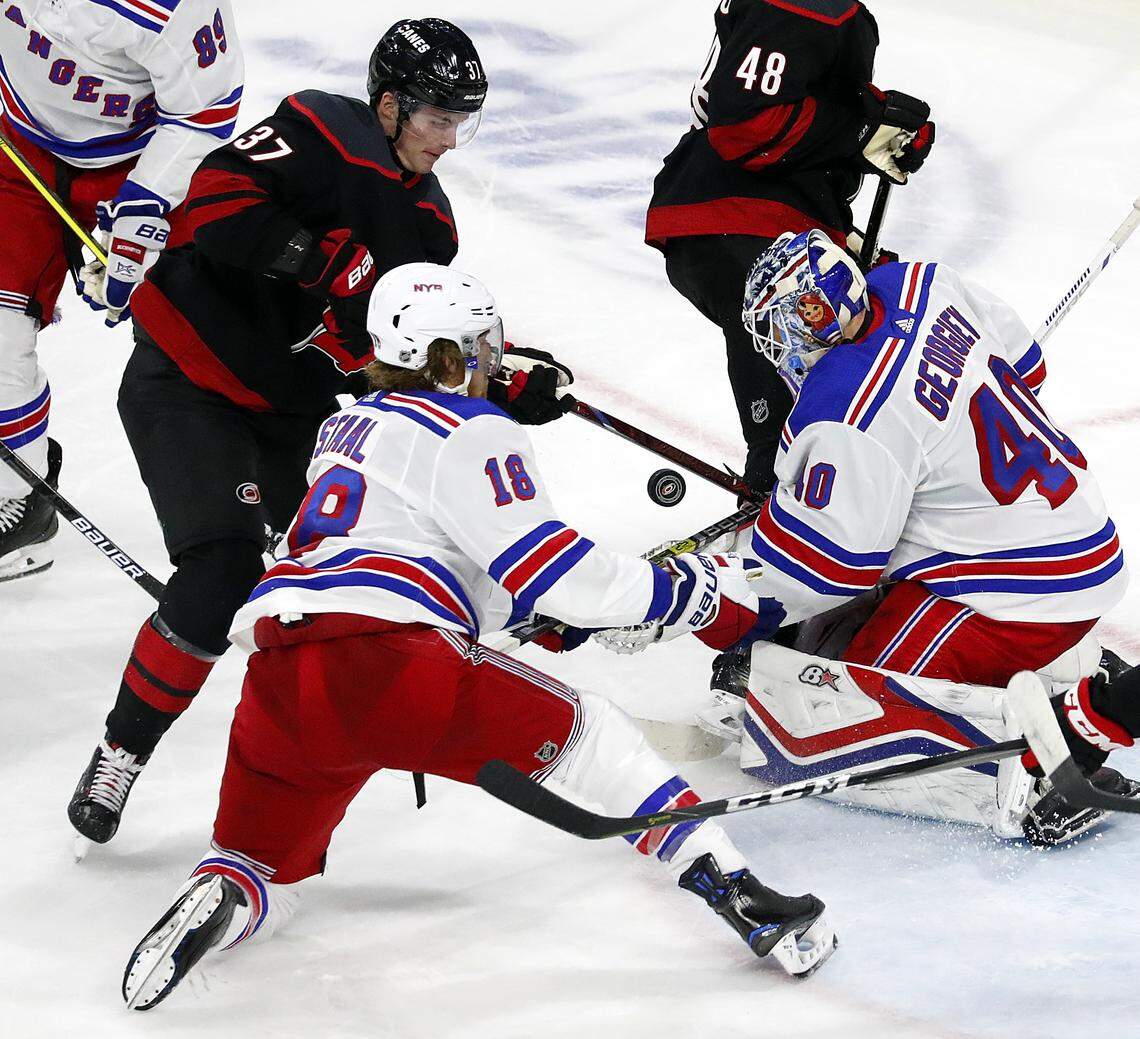 Carolina Hurricanes’ Andrei Svechnikov (37) battles with New York Rangers’ Marc Staal (18) and goaltender Alexandar Georgiev (40) for the puck during the third period of an NHL hockey game, Sunday, Oct. 7, 2018, in Raleigh, N.C. 