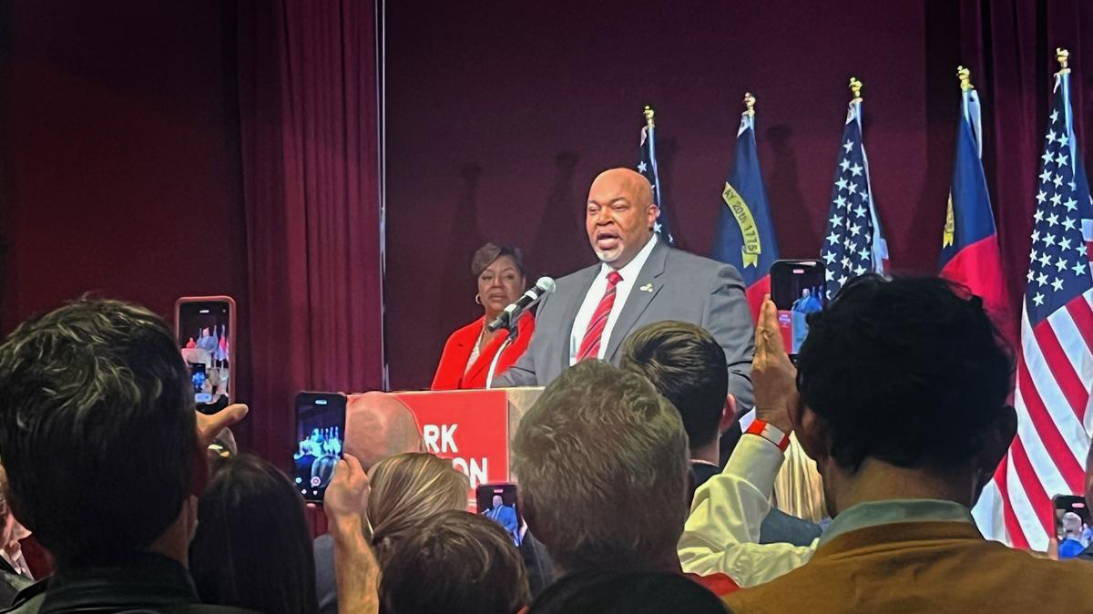 N.C. Republican Lt. Gov. Mark Robinson takes the stage on Tuesday, March 5, 2024 after winning the primary election for governor. His wife, Yolanda Hill, is on stage behind him.
