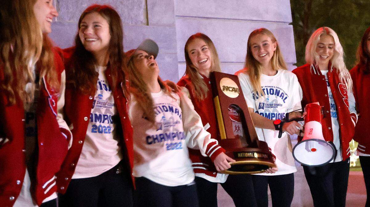From left, members of N.C. State women’s cross country team including, Kelsey Chmiel, Brooke Rauber, Alyssa Hendrix, Sam Bush (with trophy), Katelyn Tuohy and Sydney Seymour celebrate with fans outside the Memorial Belltower after returning to Raleigh after winning the NCAA Division I cross country championship Saturday, Nov. 19, 2022.