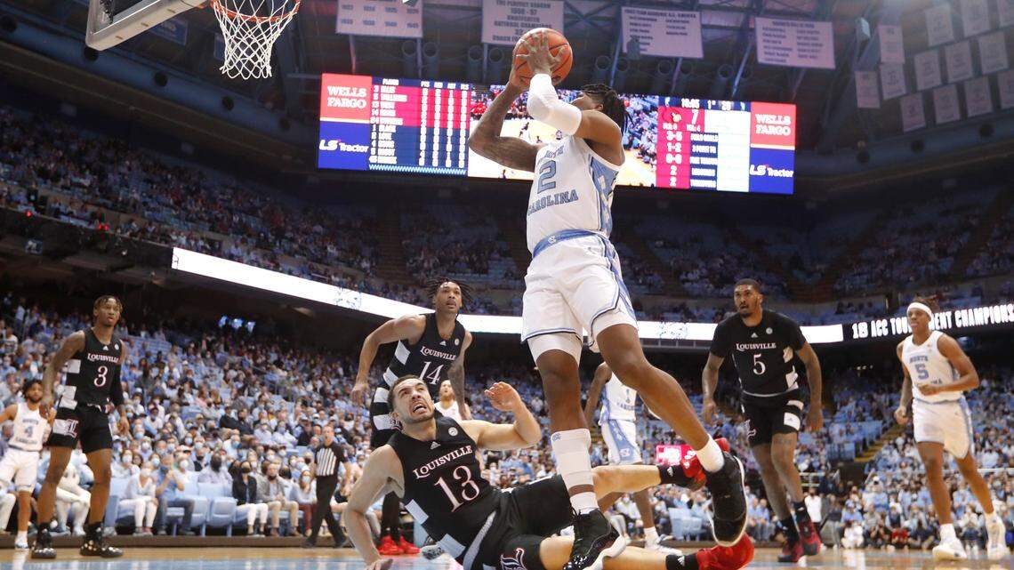 North Carolina’s Caleb Love (2) shoots over a falling Louisville’s Jarrod West (13) during UNC’s 70-63 victory over Louisville at the Smith Center in Chapel Hill, N.C., Monday, Feb. 21, 2022.