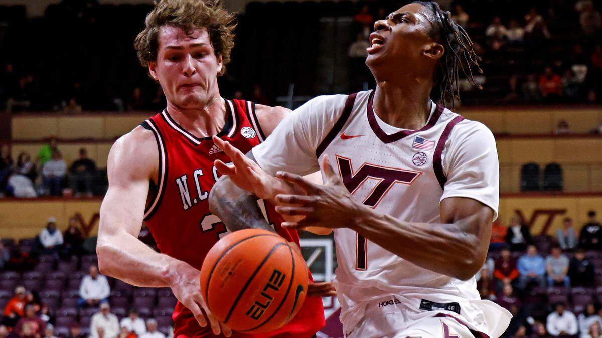 Jan 15, 2025; Blacksburg, Virginia, USA; North Carolina State Wolfpack forward Ben Middlebrooks (34) knocks the ball away from Virginia Tech Hokies forward Tobi Lawal (1) during the first half at Cassell Coliseum. Mandatory Credit: Peter Casey-Imagn Images