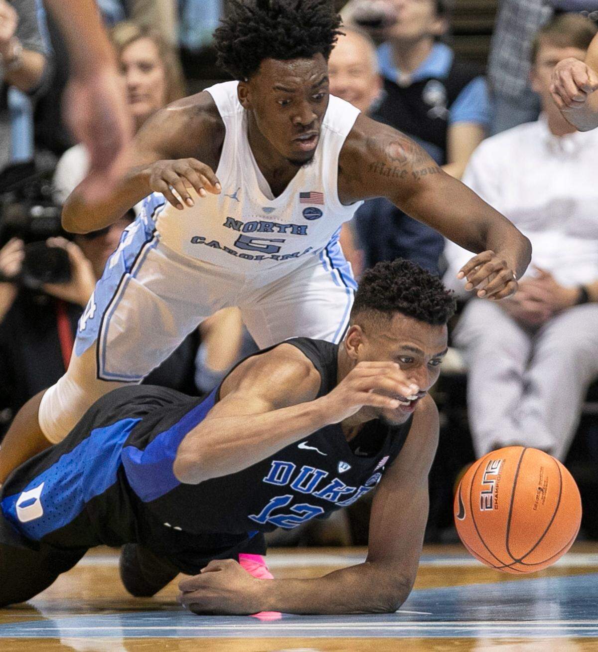 Duke’s Javin DeLaurier (12) and North Carolina’s Nassir Little (5) hustle after a loose ball. The two teams have already played three times in the past five weeks, with the Tar Heels winning twice.