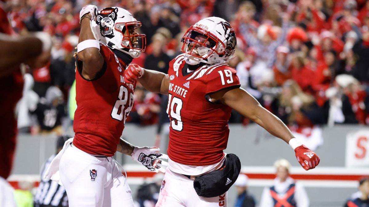 N.C. State’s Devin Carter (88) celebrates with C.J. Riley (19) after Riley returned a blocked punt for a touchdown during the first half of N.C. State’s game against UNC at Carter-Finley Stadium in Raleigh, N.C., Friday, November 26, 2021.