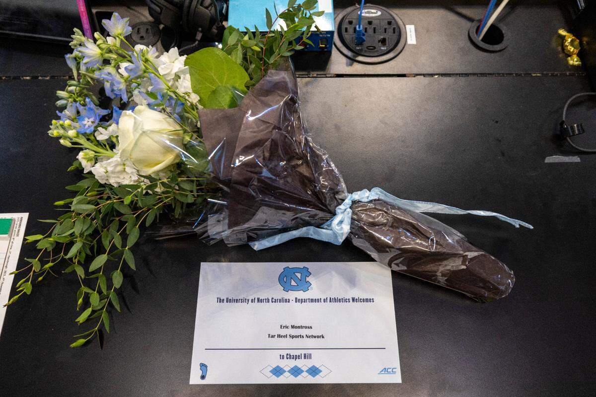A memorial for former North Carolina player Eric Montross and is set up court side beside radio announcer Jones Angell, prior to the Tar Heels’ game against Charleston Southern on Friday, December 29, 2023 at the Smith Center in Chapel Hill, N.C. Montross who died of cancer on December 17, 2023 was the color commentator for the Tar Heel Sports Network.
